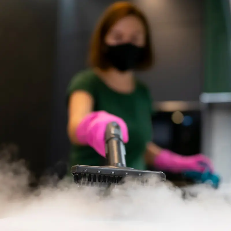 female professional cleaner using a steamer during deep cleaning at home