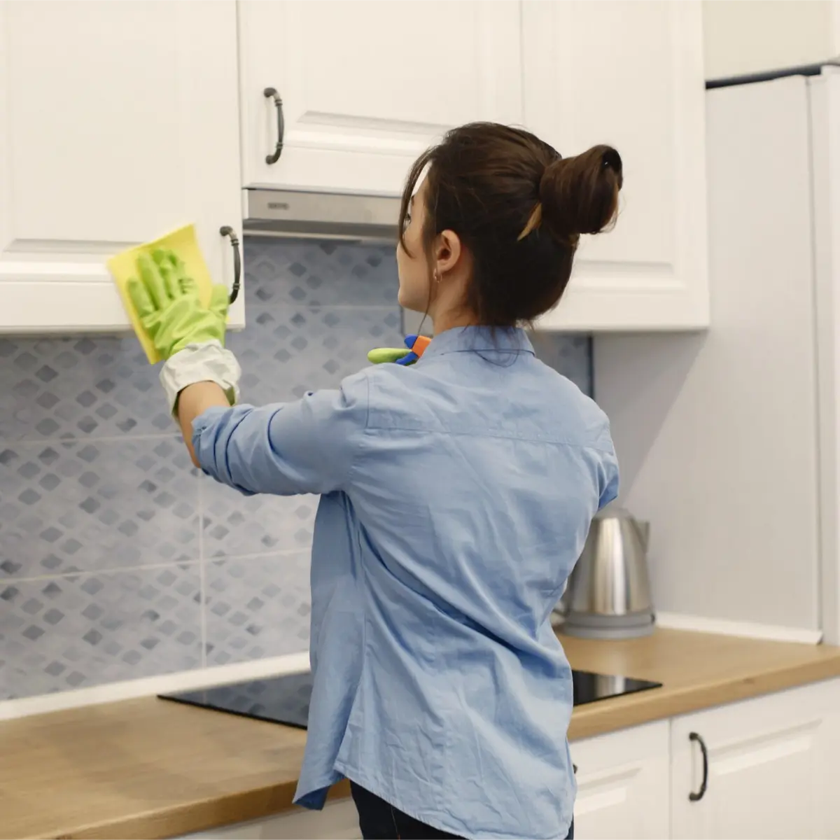 professional cleaner cleaning the kitchen cabinets during house cleaning services in Surrey