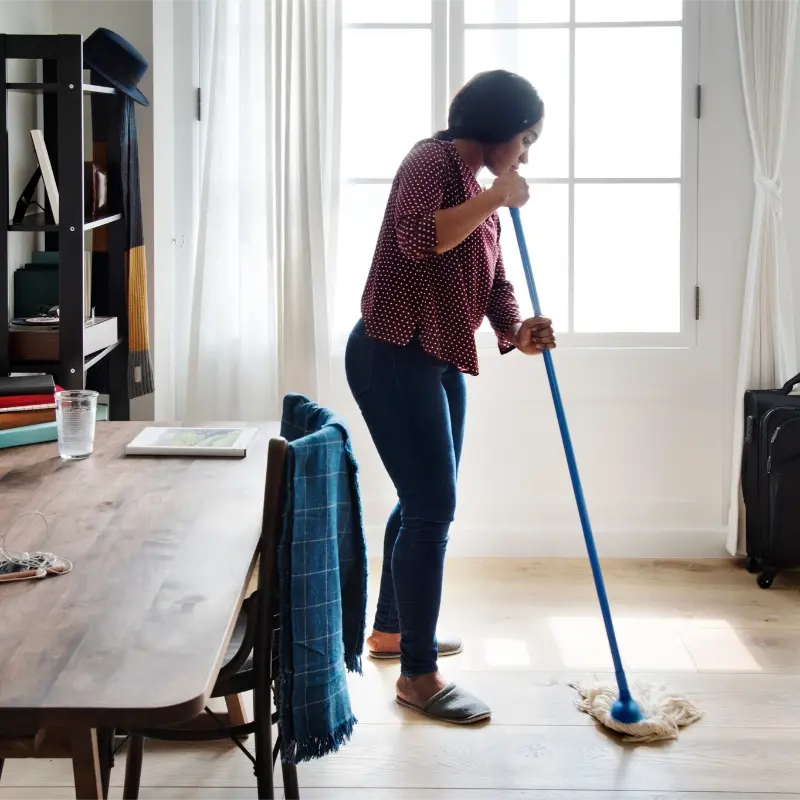 woman professional cleaner mopping the living room floor during professional house cleaning services in North Vancouver