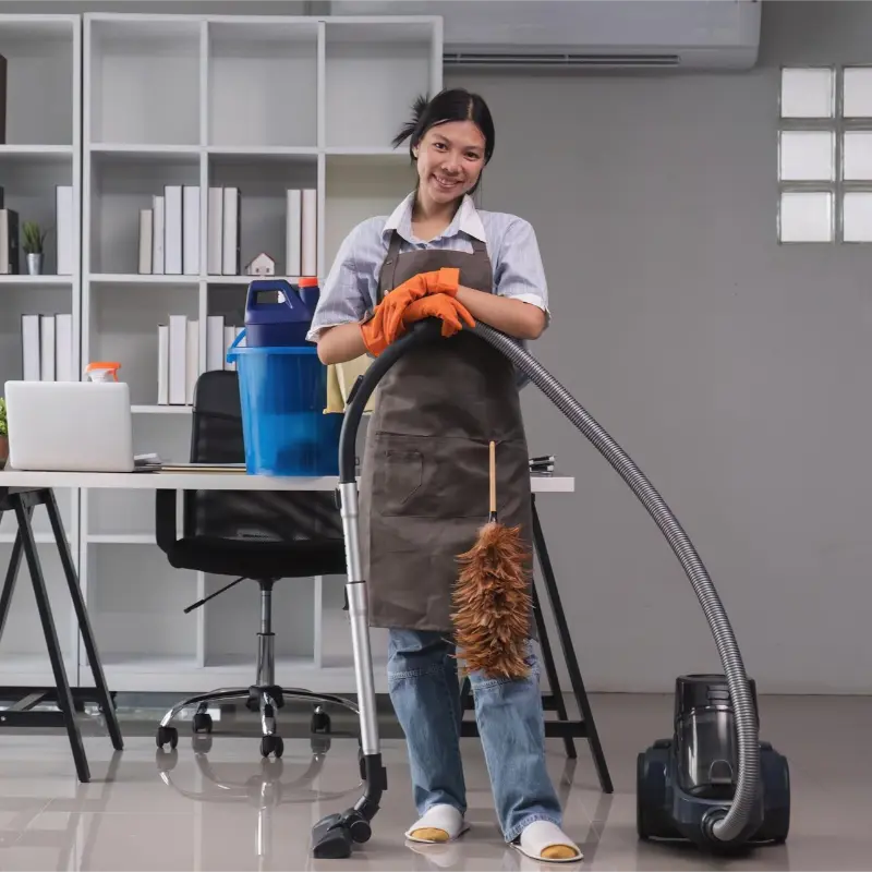 professional cleaner with a vacuum and duster after completing a deep cleaning at home