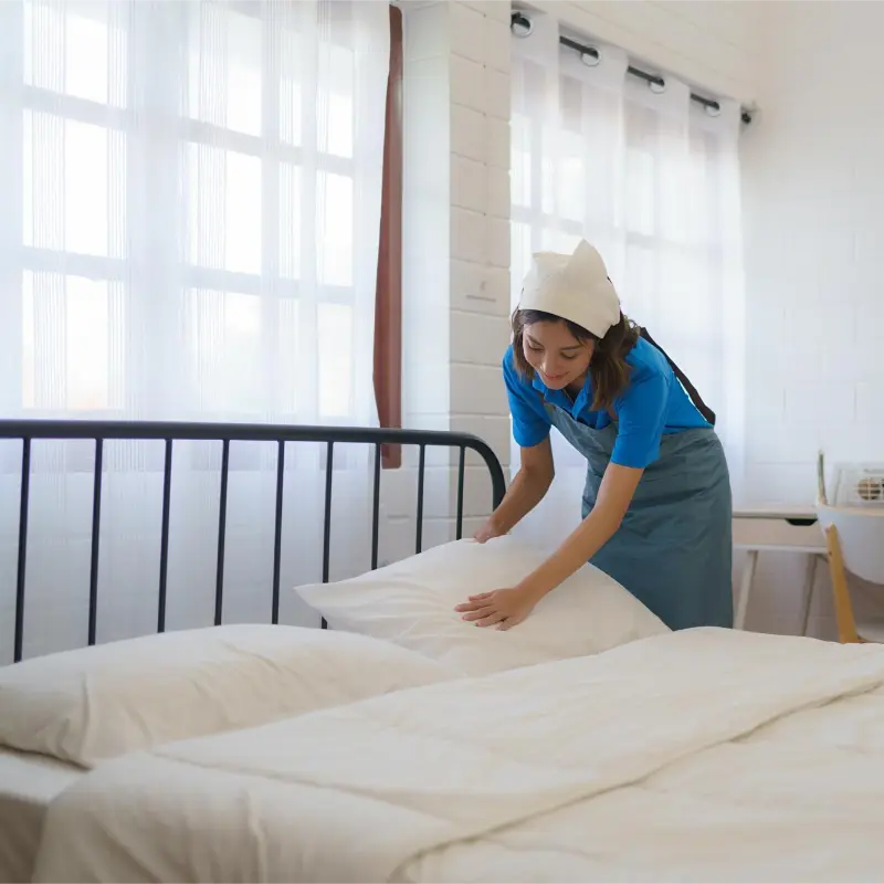 women professional cleaning the bedroom during the professional house cleaning services
