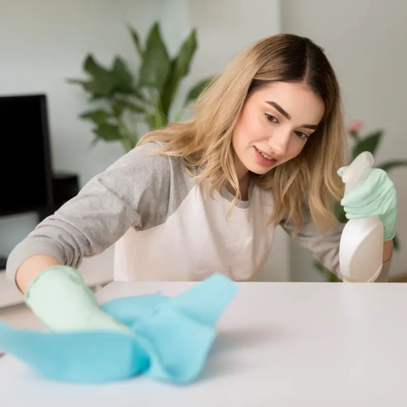 female cleaning professional sanitizing the table during professional cleaning in Langley