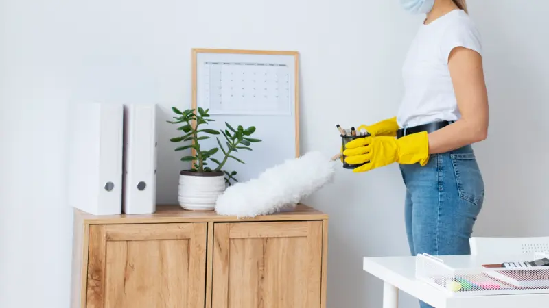 woman professional cleaner dusting the living room during professional house cleaning services in North Vancouver
