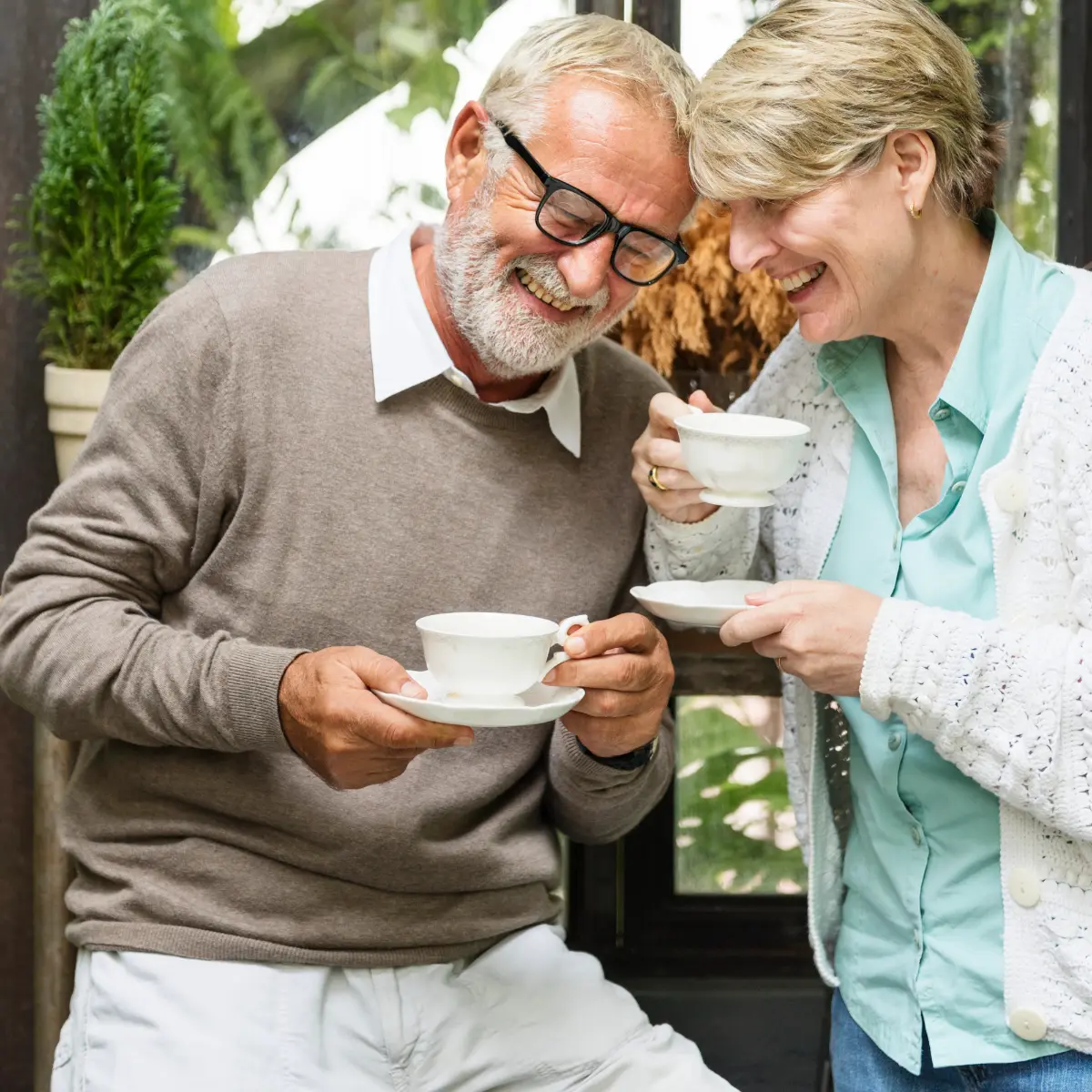 happy seniors enjoying at home after professional cleaning services infemale cleaning professional sanitizing the table during professional cleaning services in Langley