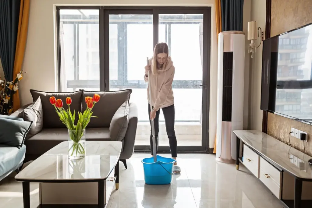 female professional cleaning up a sunlit living space