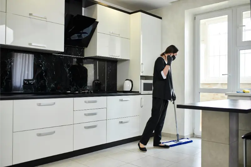 female professional cleaner mopping in the kitchen floor
