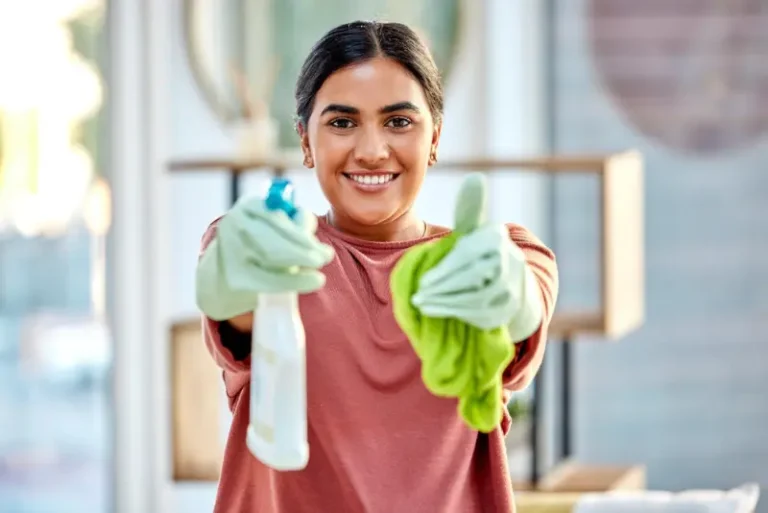 A happy cleaning professional proud of completing the job with eco-friendly products.