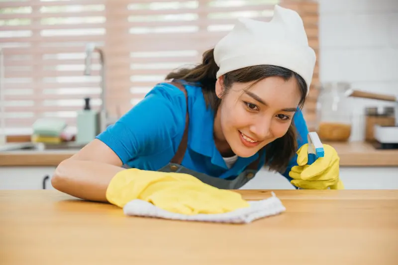 happy professional cleaner cleaning during professional house cleaning services in North Vancouver