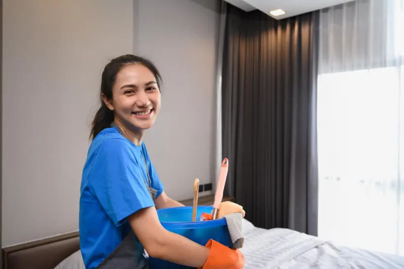 happy professional woman cleaner with supplies during professional house cleaning services in Vancouver