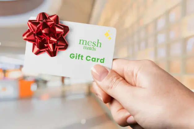Woman holding Mesh Maids gift card for cleaning services in Abbotsford