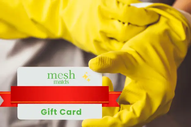 Young woman professional holding Mesh Maids gift card for cleaning services in Kelowna