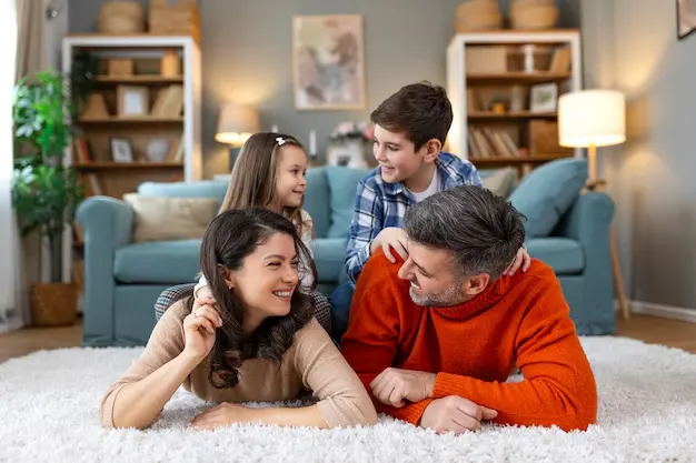 Happy family enjoying on a clean carpet after taking the help of professional cleaning services in Etobicoke