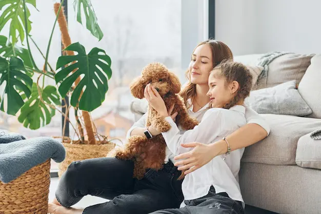 A young mother and daughter, playing with her pet after completing eco-friendly services in their Etobicoke home
