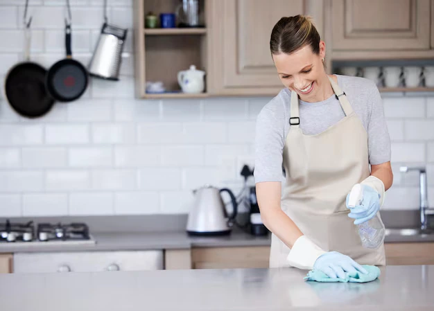 Woman professional cleaner wiping off the kitchen countertops during house cleaning services in Ajax