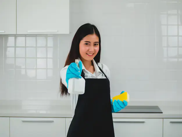 A young professional with cleaning supplies during house cleaning services in North York