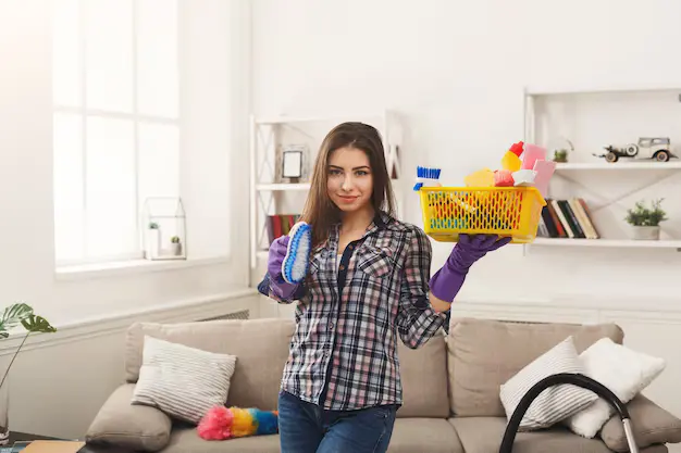 Woman cleaning professional holding cleaning supplies during house cleaning services in Markham