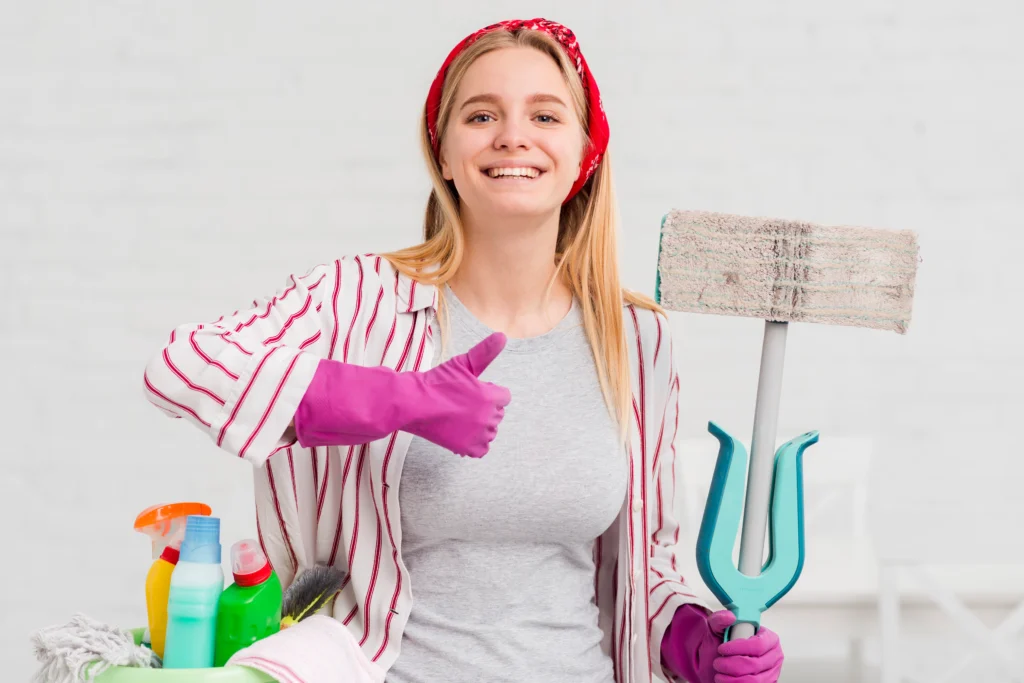 A young woman cleaning professional holding cleaning supplies and tools for cleaning services in Etobicoke