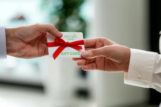 Man giving Mesh Maids Gift Card for house cleaning services in Oakville to a woman