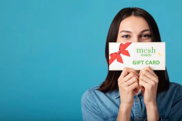 Woman holding Mesh Maids gift card for cleaning services in Whitby