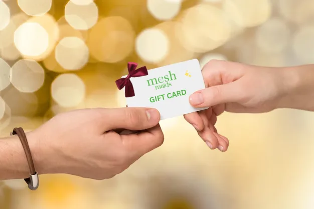 Woman giving Mesh Maids gift card to loved one to use for house cleaning services
