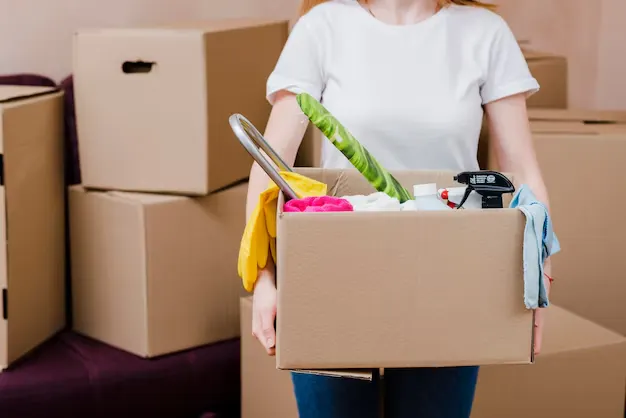 Woman holding cleaning supplies during move out cleaning services