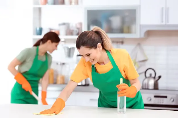 happy women professional cleaners performing a thorough deep cleaning in kitchen during house cleaning services in Oakville