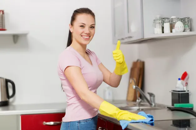 Young happy woman professional standing confidently after house cleaning services in Hamilton and Burlington