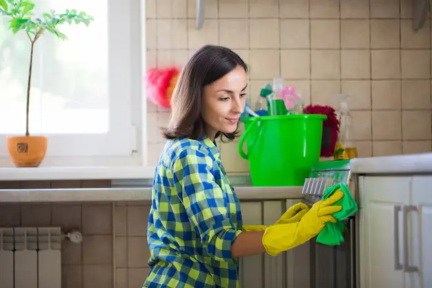Young female professional cleaning in the kitchen during cleaning services in Toronto and surrounding communities across the GTA