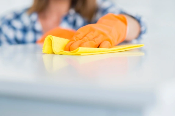Female Mesh Maids cleaner wiping table during house cleaning services in Surrey, White Rock and Delta
