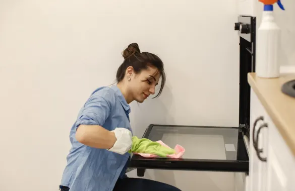 Female Mesh Maids cleaner cleaning microwave during house cleaning services in Coquitlam, Port Coquitlam & Port Moody