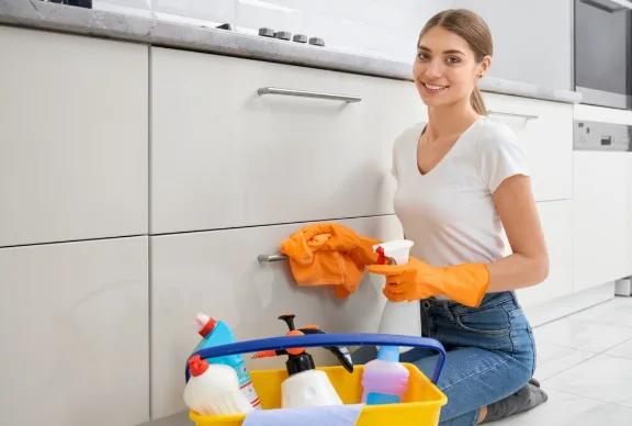 Female Mesh Maids cleaner cleaning kitchen cabinets during house cleaning services in Langley & Aldergrove