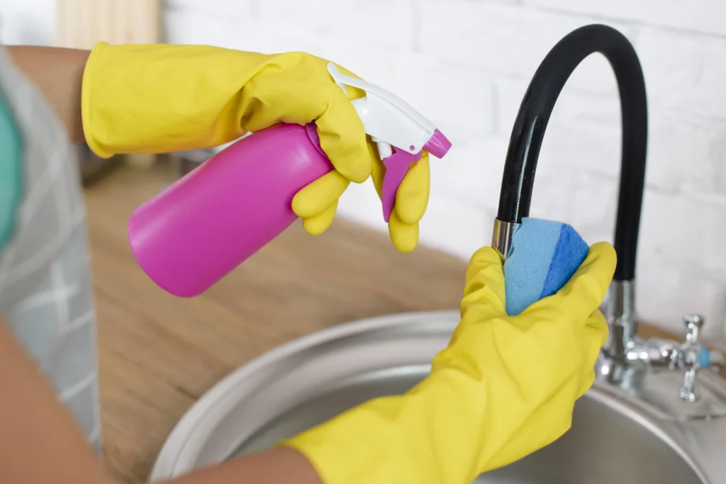 Female Mesh Maids cleaner cleaning kitchen faucets during house cleaning services in Abbotsford, Mission and Chilliwack